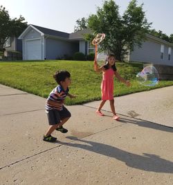 Full length of siblings playing in park