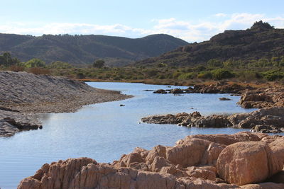 Scenic view of rocky mountains by sea