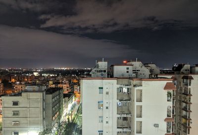 High angle view of illuminated buildings against sky at night