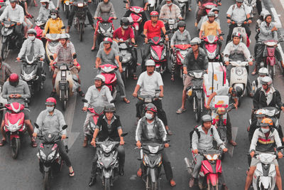 High angle view of people riding motor vehicles on road in city