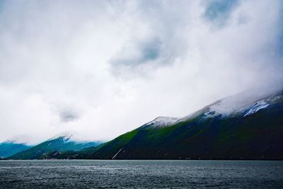 Scenic view of sea and mountains against sky