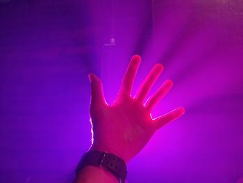 Close-up of hand against illuminated light