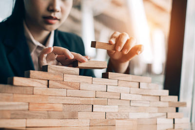 Close-up of woman holding stack of wood