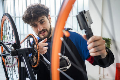 Portrait of man working with bicycle