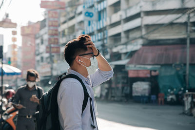 Man standing on street in city