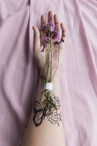 Hand with flowers and tattoos