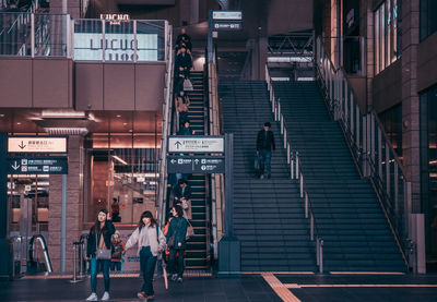 People walking on staircase in city