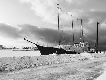 Boats moored on beach against sky