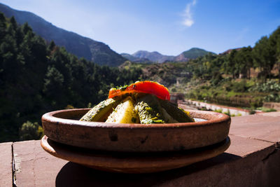 Close-up of bananas on table against mountains