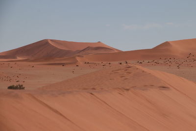 Sand dunes in desert against sky