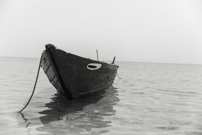 Boat moored in sea against clear sky