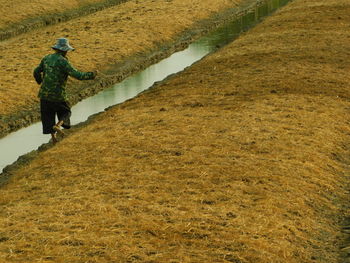 Side view of man walking on field