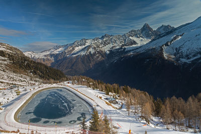 Scenic view of pond against snowcapped mountain