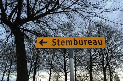 Low angle view of sign board against sky