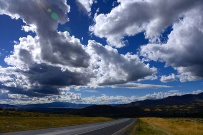 Country road against cloudy sky