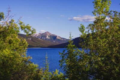 Scenic view of lake and mountains against blue sky