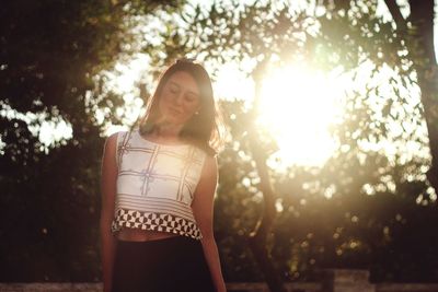 Woman with arms raised against trees