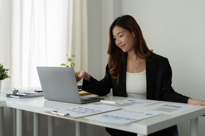 Businesswoman using laptop at office