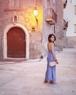 Full length of woman standing against building