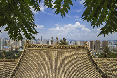 View of city buildings against cloudy sky