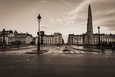 View of city street against cloudy sky