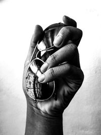Close-up of man holding camera over white background