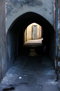 Empty alley amidst buildings in tunnel