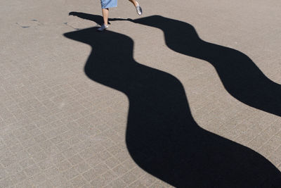 Low section of woman standing on shadow