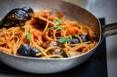 High angle view of noodles and clams in cooking pan