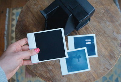 Directly above shot of hand holding book on table