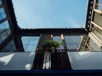 Low angle view of glass building against sky