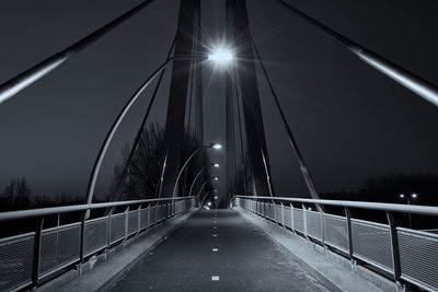 Illuminated bridge against sky at night