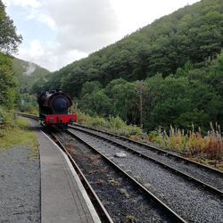 Train by railroad tracks against sky