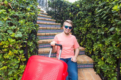 Mid adult man wearing sunglasses against plants