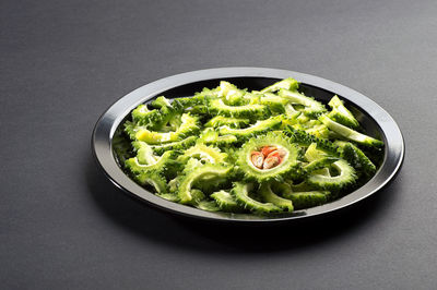 High angle view of vegetables in bowl against black background