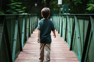 Full length rear view of man standing on railing