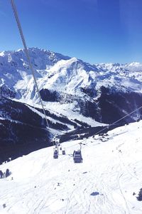 Scenic view of snowcapped mountains against blue sky