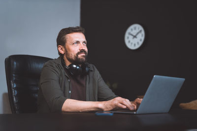Portrait of young man using laptop at home