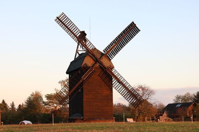 Traditional windmill on field against sky