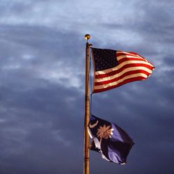 Low angle view of flag against cloudy sky