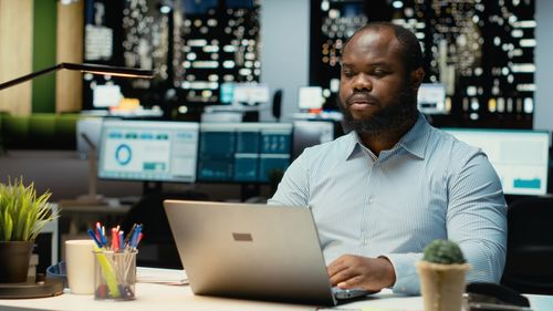 Young man using laptop at cafe