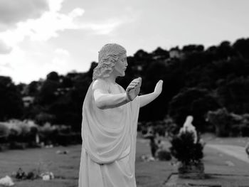 Statue on cross against sky