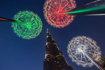 Low angle view of illuminated ferris wheel against sky at night