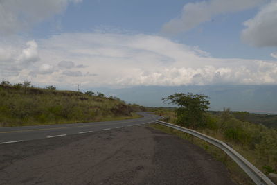 Road by trees against sky