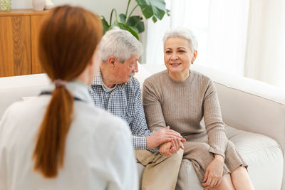 Portrait of smiling couple sitting on sofa at home