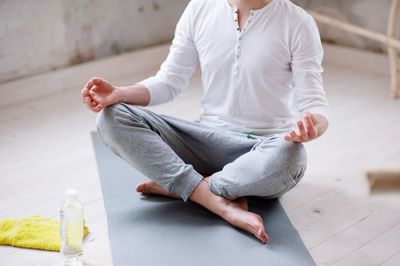 Low section of man doing yoga in studio