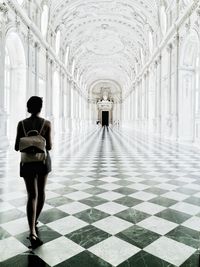 Rear view of man walking in corridor of building