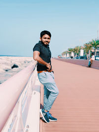 Portrait of young man standing against clear sky