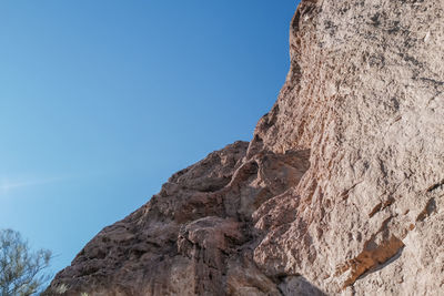 Low angle view of rock formation against clear blue sky