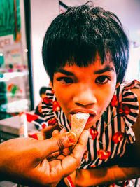 Close-up portrait of boy holding camera